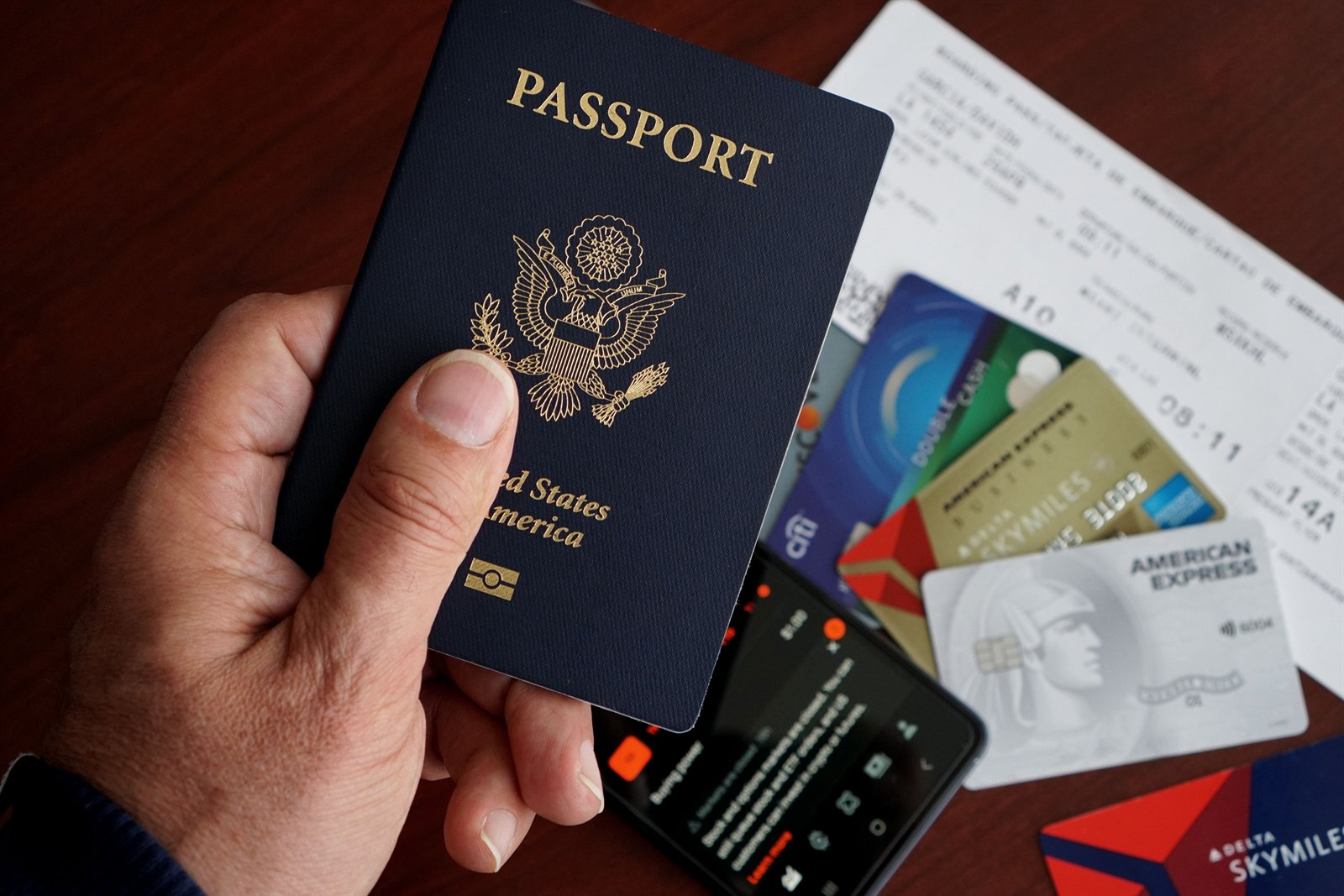 Passport, travel tickets, credit cards, and a mobile phone on a table