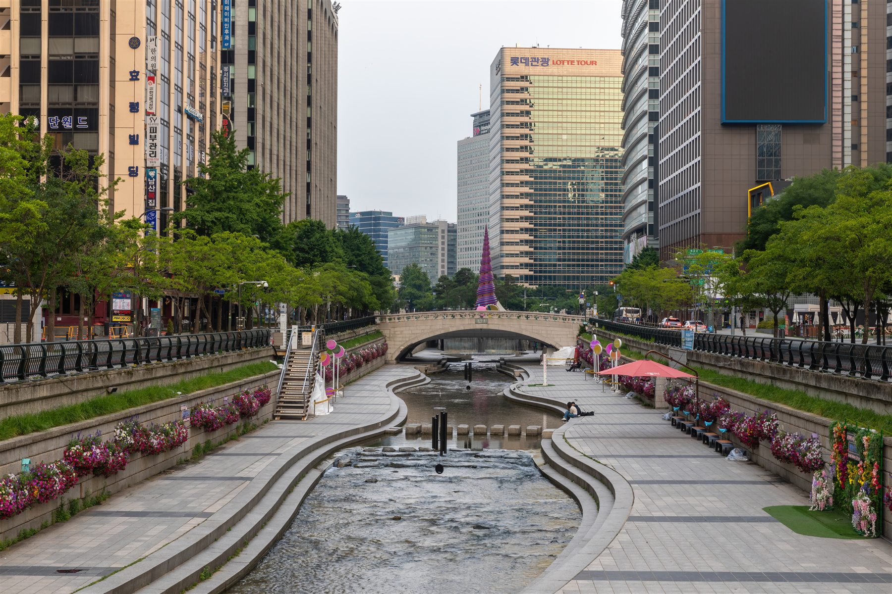 Cheonggyecheon Stream with flowers and a bridge near Cheonggye Plaza in Seoul