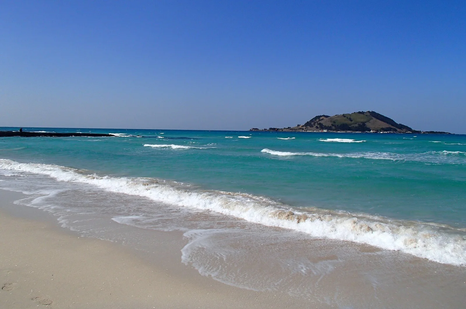 Turquoise water and pale sand at Hyeopjae Beach on Jeju Island