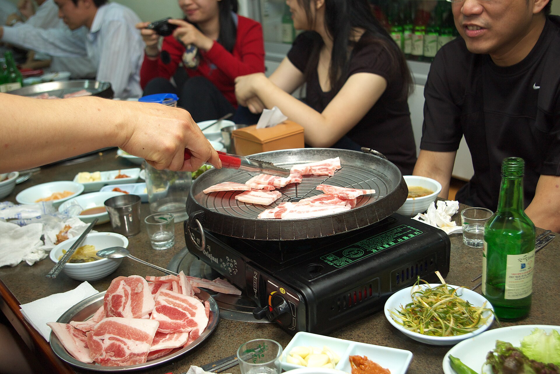 Samgyeopsal pork belly cooking on a Korean barbecue grill