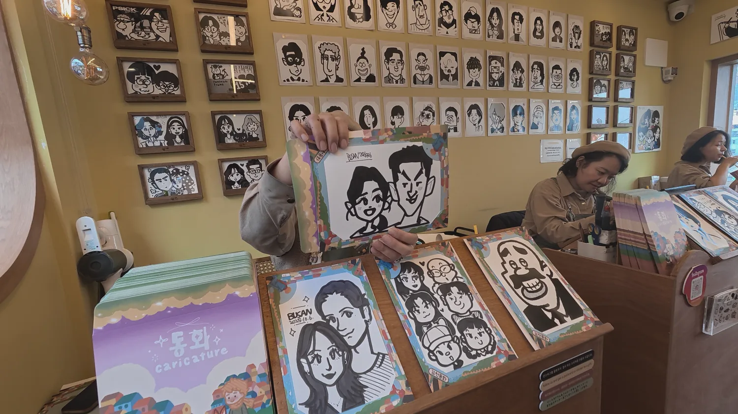 Dotoricaricature shop interior with hand-drawn caricature portraits in Gamcheon Culture Village.