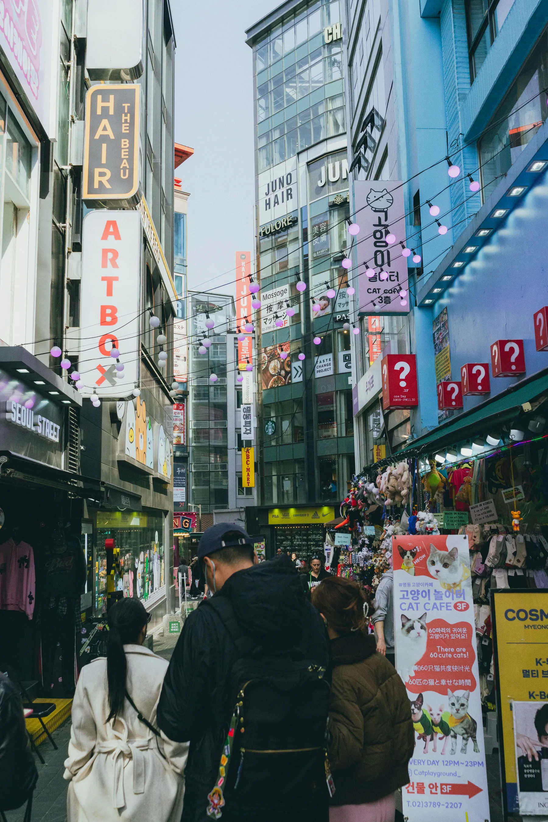 Travelers walking through the shops and signs of Myeongdong in Seoul