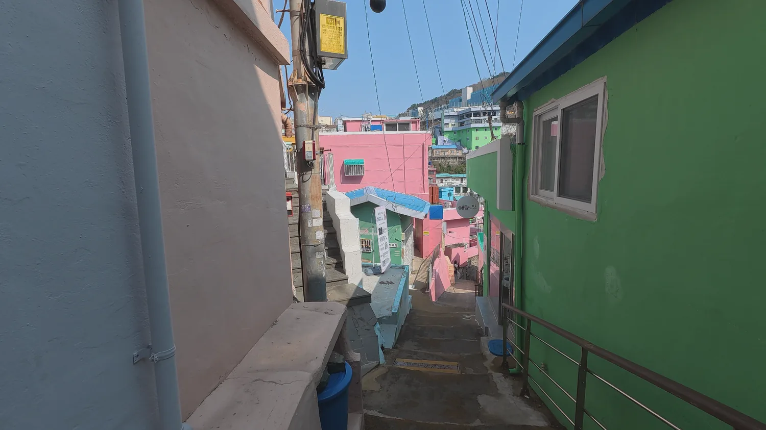 Narrow colorful alley with stairs between painted houses in Gamcheon Culture Village.