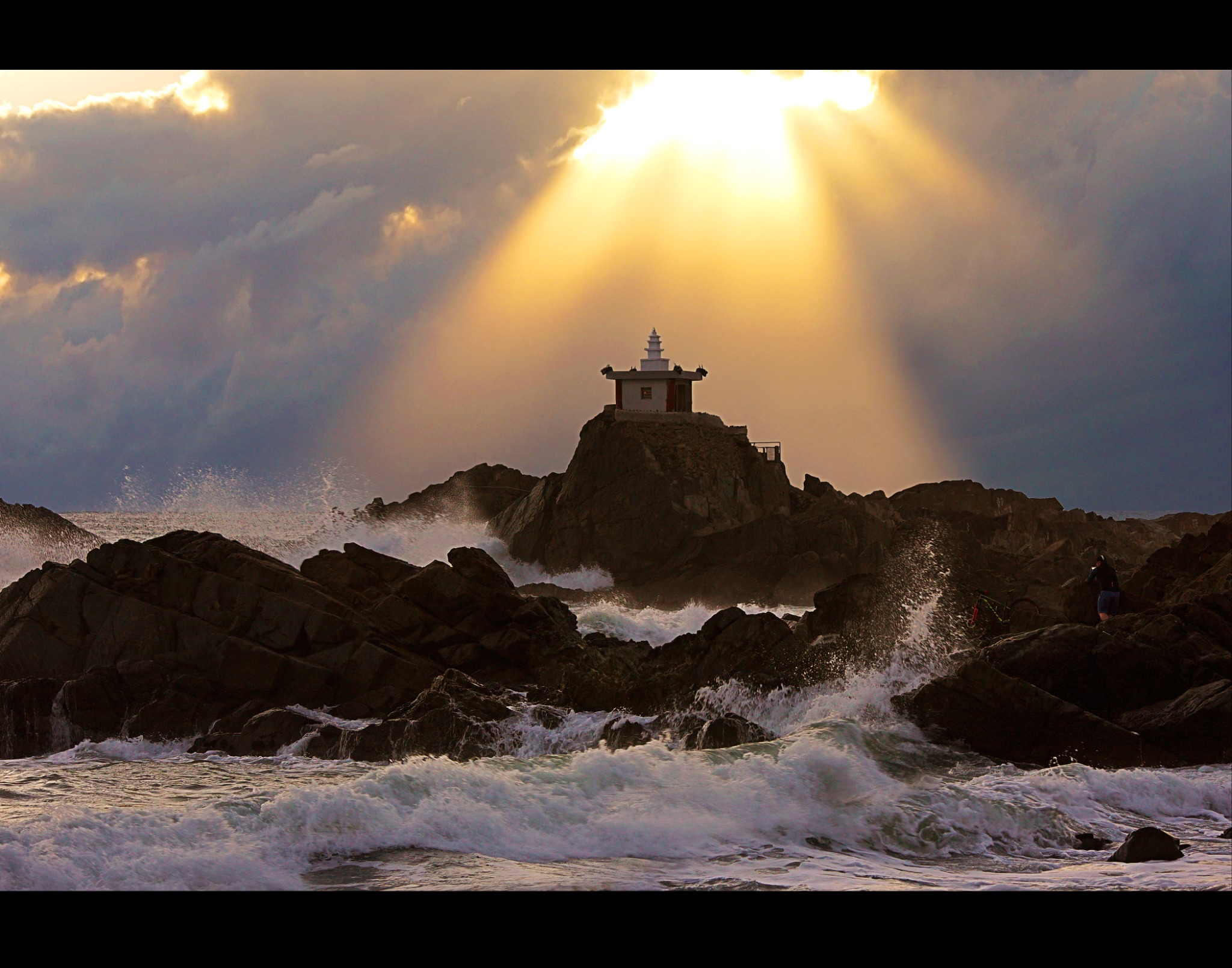Waves breaking around the coastal shrine at Orangdae
