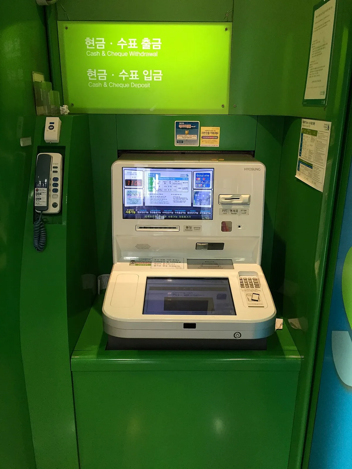 A Korean ATM with cash withdrawal and deposit signs in Korean and English