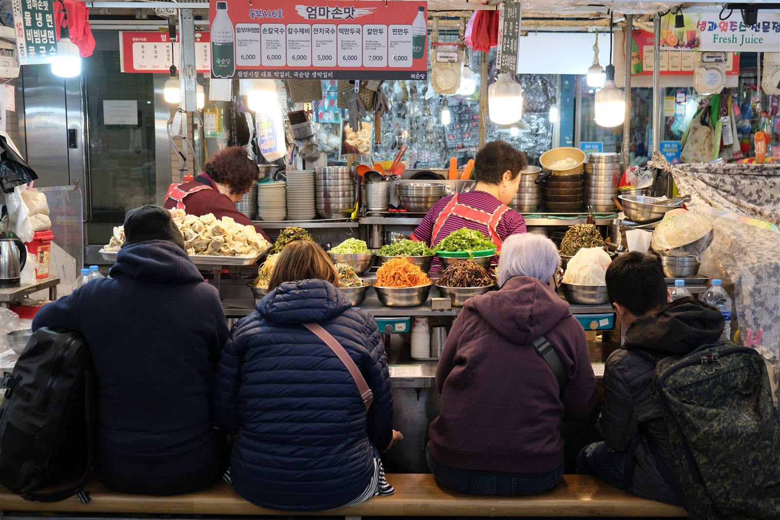 Food vendors serving customers at Gwangjang Market in Seoul