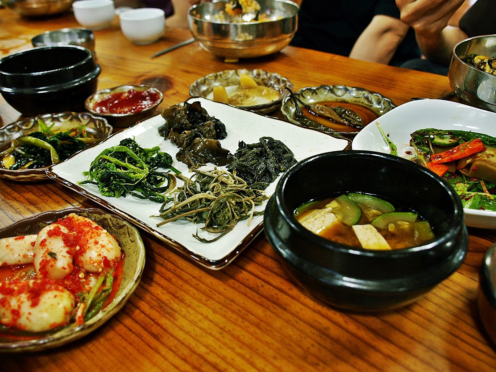 Doenjang jjigae served with Korean side dishes on a restaurant table