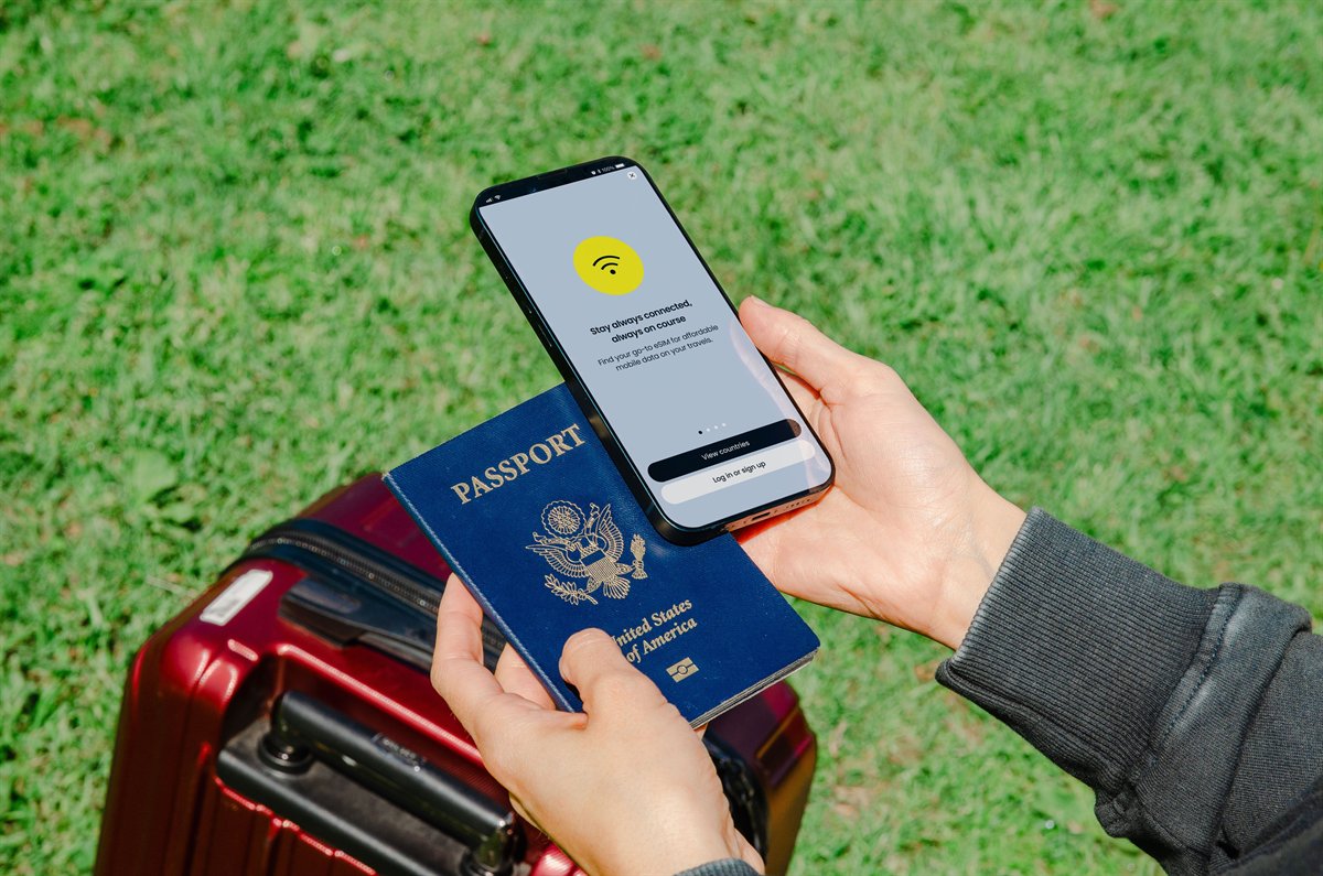 Person holding a passport and smartphone while preparing for travel