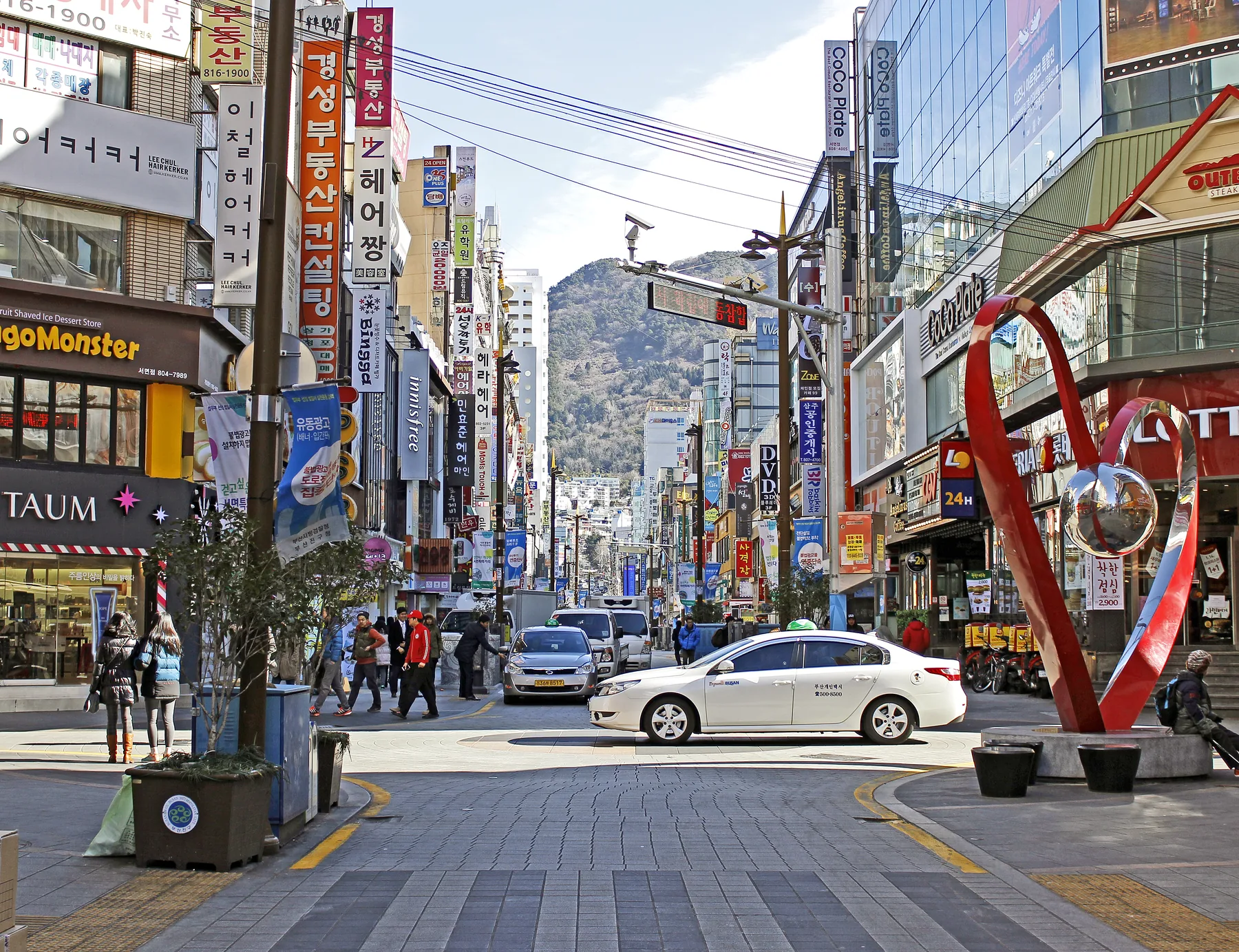 Street view of central Seomyeon in Busan with shops and city buildings.